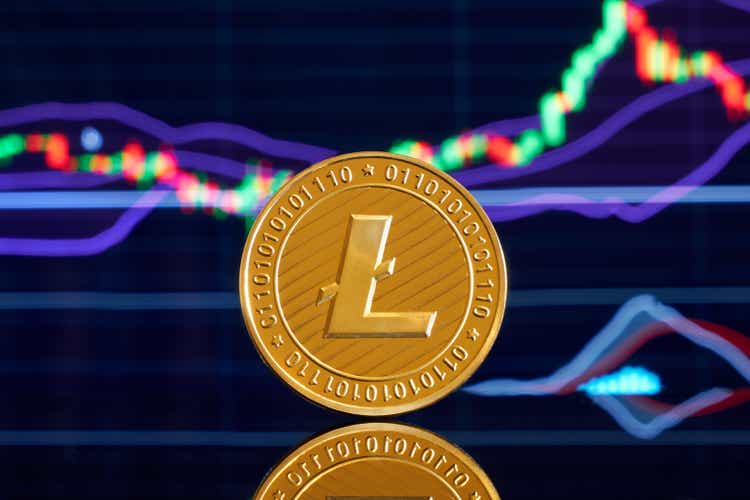 Moneda de oro litecoin sobre un fondo brillante de primer plano de gráficos de negocios.  Criptomoneda.  Anónimo.  Moneda virtual