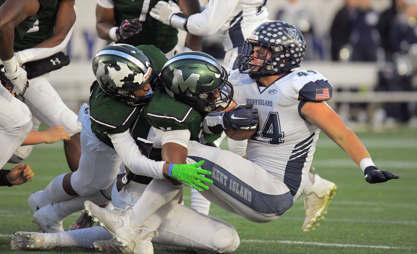 Los apoyadores de Milford Mill, Coby Jones, a la izquierda, y Malachi Barnes abordan al corredor de Kent Island, Kasey Heath, durante el primer cuarto del juego de campeonato estatal Clase 2A del viernes en el Navy-Marine Corps Memorial Stadium.