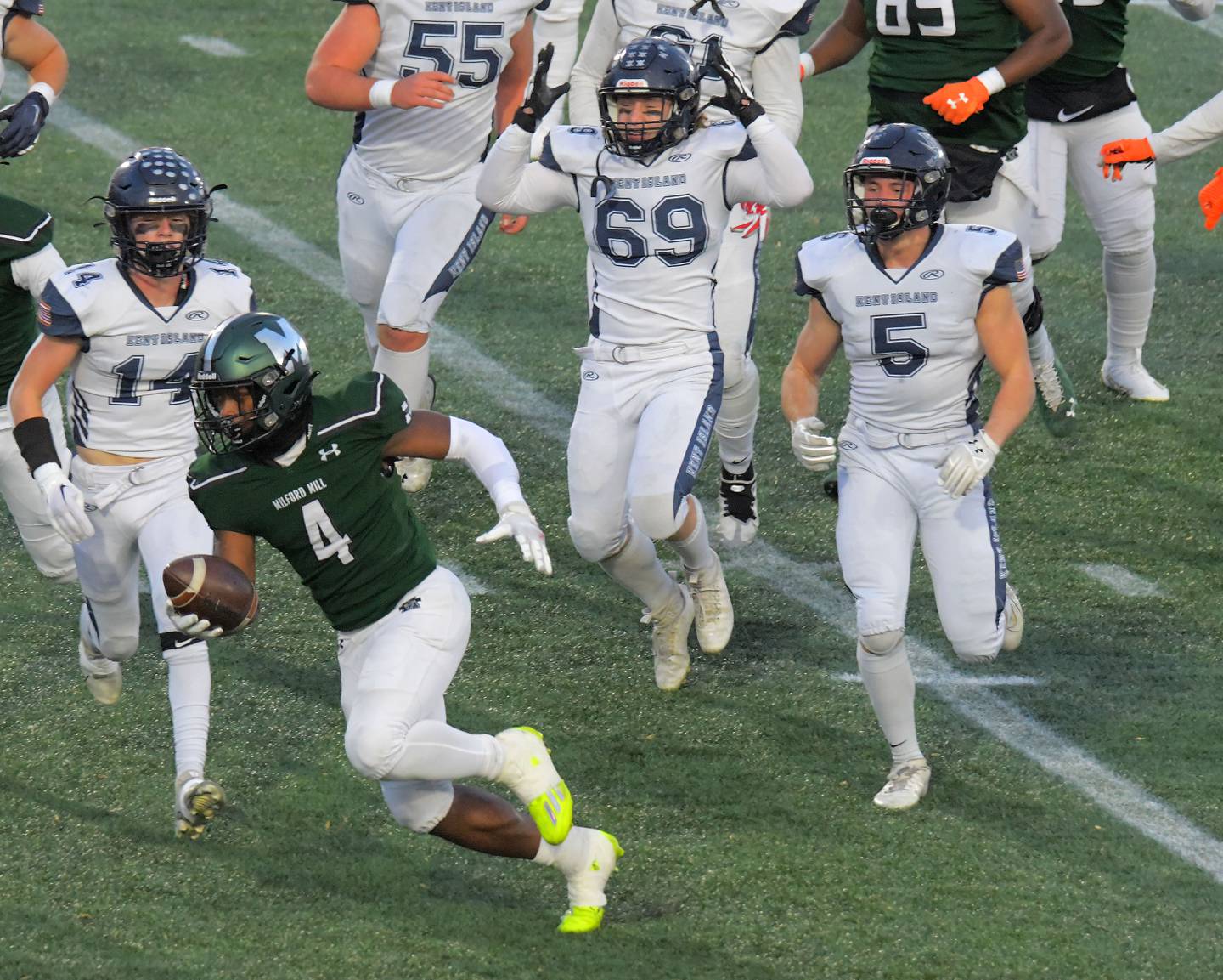 El back defensivo de Kent Island, Keegan O'Brien (14), el apoyador Giuseppe Mellinger (69) y el ala defensiva Dalton Mason (5) ven al atleta de Milford Mill, Sean Williams (4), correr hacia la zona de anotación para un touchdown durante el primer cuarto de la clase del viernes. 2Un juego de campeonato estatal en el Navy-Marine Corps Memorial Stadium.