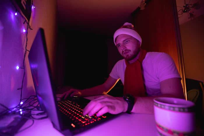 Persona con gorra de Papá Noel trabajando en una laptop.