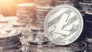 Moneda Litecoin de plata mirando hacia adelante sobre un montón de litecoins