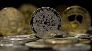 La ficha de Cardano con otras fichas de oro y plata al fondo.