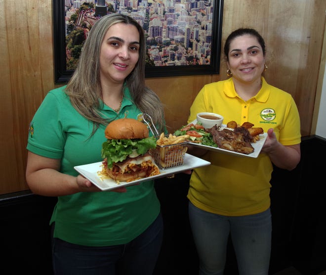 Las copropietarias y hermanas de Taste of Brazil, Jacqualine Macedo de Hanson y Aline Macedo de Whitman, muestran su sándwich X Brazil y platos Plate of The Day, dos de los platos principales más populares que sirven en su popular restaurante en Crescent Street en Brockton el jueves. , 16 de marzo de 2023.