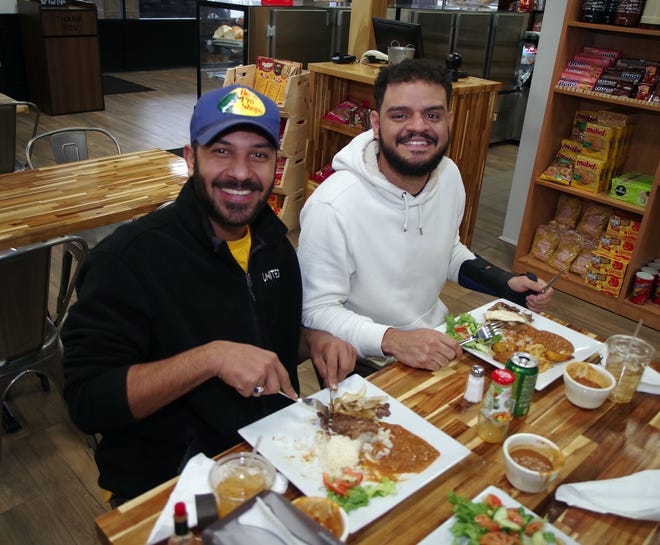 Samuel Gomes, que viene desde Saugus, y Arthur Pechin de Haliax, se sientan a comer en Taste of Brazil en Brockton el jueves 16 de marzo de 2023.