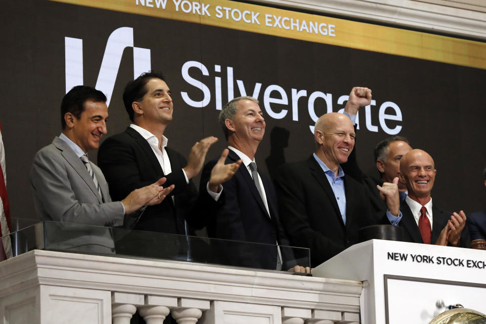 El CEO de Slivergate, Alan Lane, segundo desde la derecha, es aplaudido cuando toca la campana de apertura de la Bolsa de Valores de Nueva York antes de que comience a cotizar la oferta pública inicial de su banco, el jueves 7 de noviembre de 2019. (Foto AP/Richard Drew)