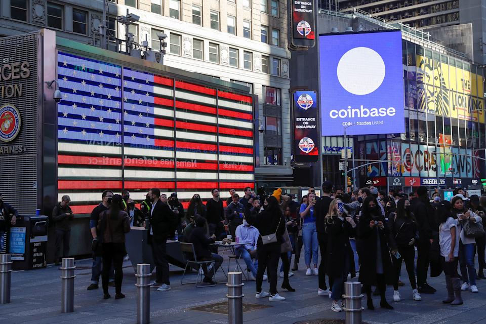 Empleados de Coinbase Global Inc, el mayor intercambio de criptomonedas de EE. UU., observan cómo se muestra su listado en el jumbotron Nasdaq MarketSite en Times Square en Nueva York, EE. UU., 14 de abril de 2021. REUTERS/Shannon Stapleton