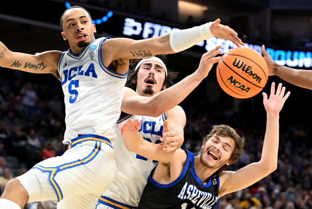 Amari Bailey y Jaime Jaquez Jr. de UCLA luchan por un rebote con Fletcher Abee de UNC Asheville.