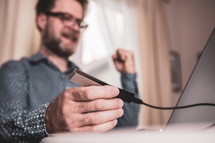 Persona que sostiene un dispositivo de hardware conectado a la computadora.