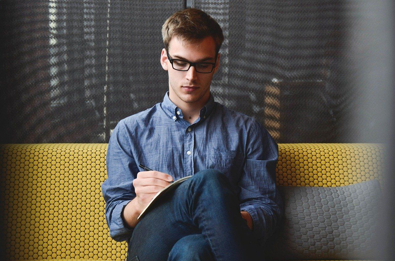 joven sentado y escribiendo