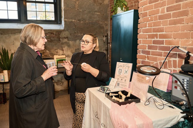 Andreea Furtado, a la derecha, propietaria de BrowTourage, comparte su negocio con un invitado en Bowties and Blazers de EforAll, celebrando la cohorte de graduados de invierno de 2023 el 18 de abril.