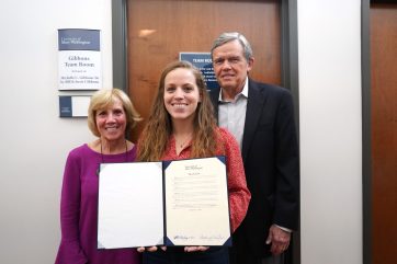 Michelle Gibbons '16, con sus padres, Bill y Susie Gibbons, sostiene la resolución de BOV que nombra el Gibbons Team Room, un espacio de colaboración y estudio que se utilizará para los estudiantes de negocios en los años venideros. Foto de Suzanne Carr Rossi.