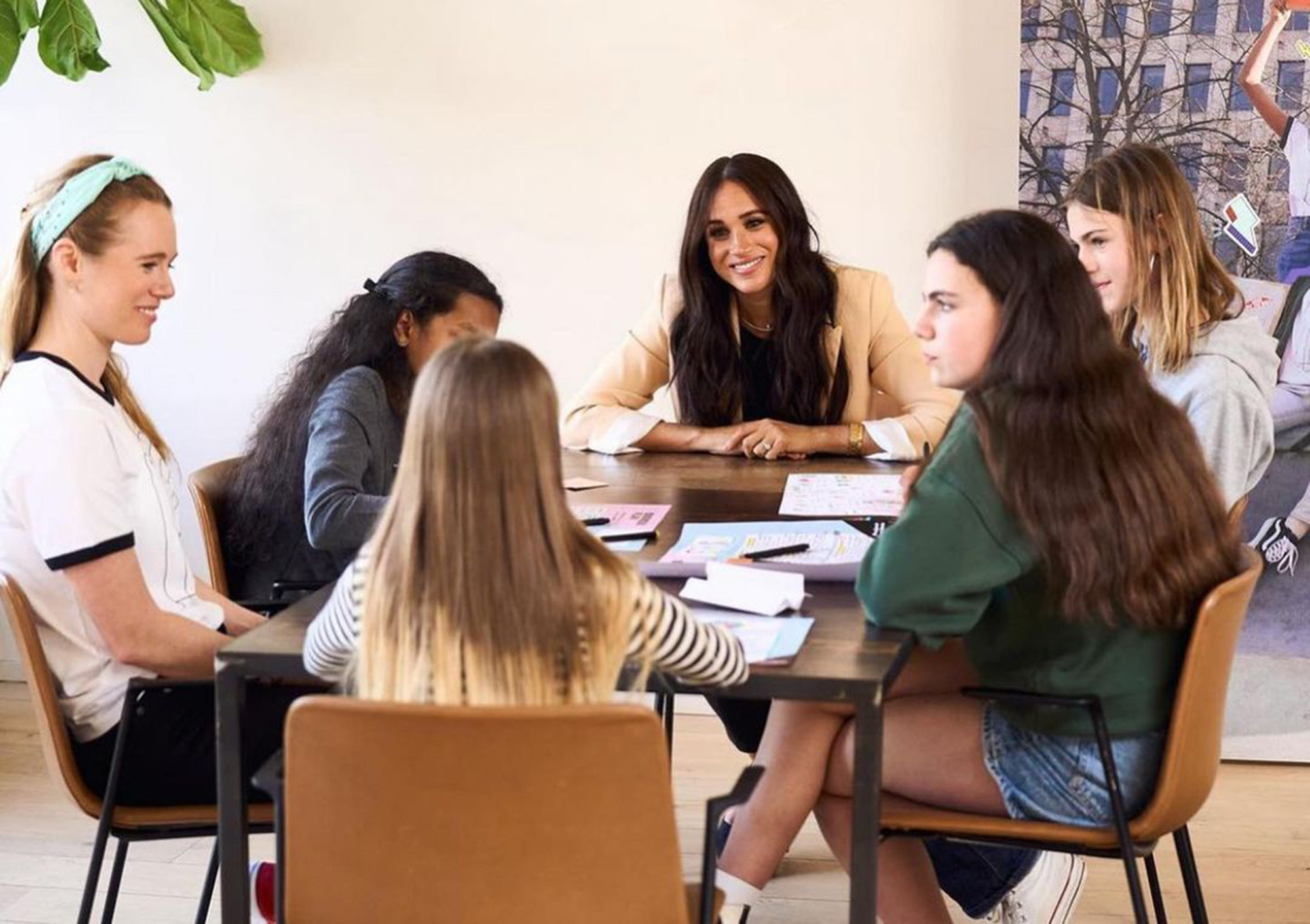 Meghan Markle en una mesa con empleados. 