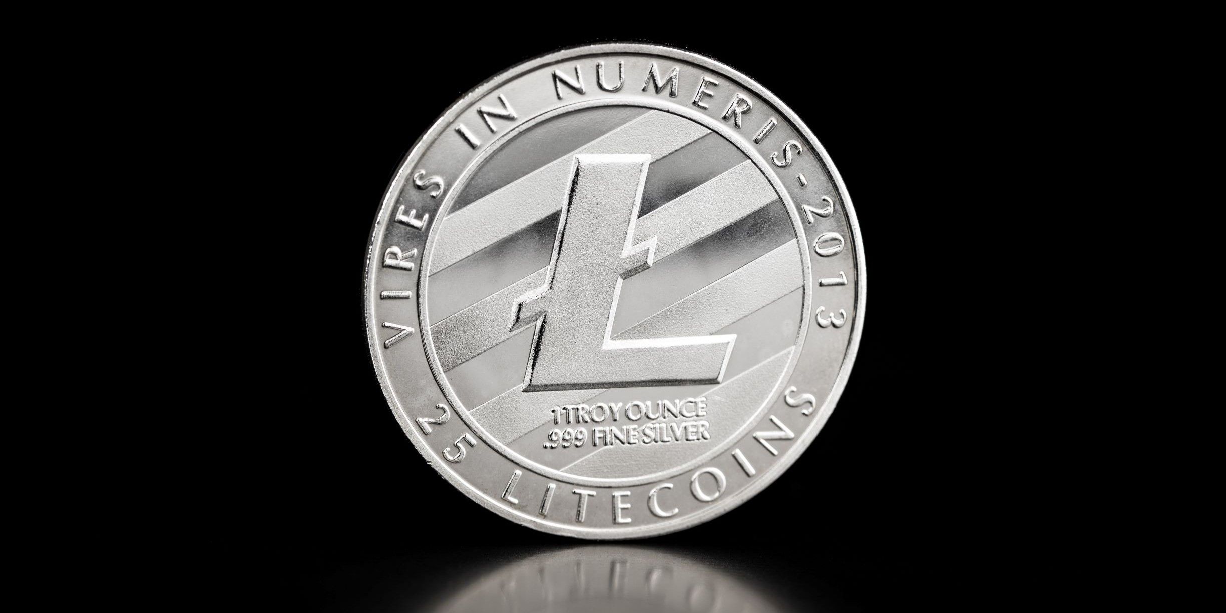 Moneda de plata con logo Litecoin sobre fondo negro