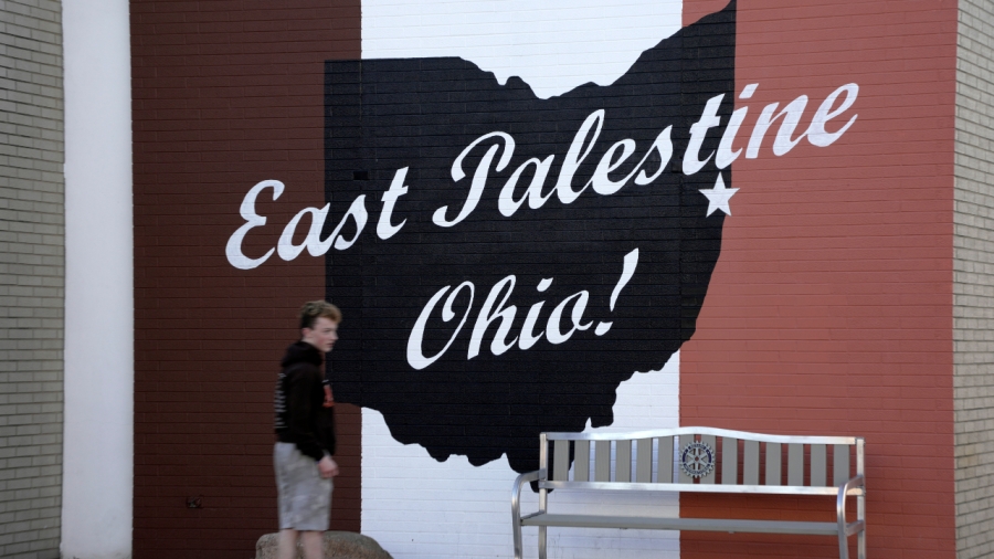 ARCHIVO - Un patinador pasa un letrero en el centro de East Palestine, Ohio, mientras continúa la limpieza de partes de un tren de carga de Norfolk Southern que descarriló hace más de una semana, el 15 de febrero de 2023. Después del catastrófico descarrilamiento de un vagón de tren en East Palestine, Ohio , algunos funcionarios están expresando su preocupación por un tipo de sustancia tóxica que tiende a permanecer en el medio ambiente.  (Foto AP/Gene J. Puskar, archivo)