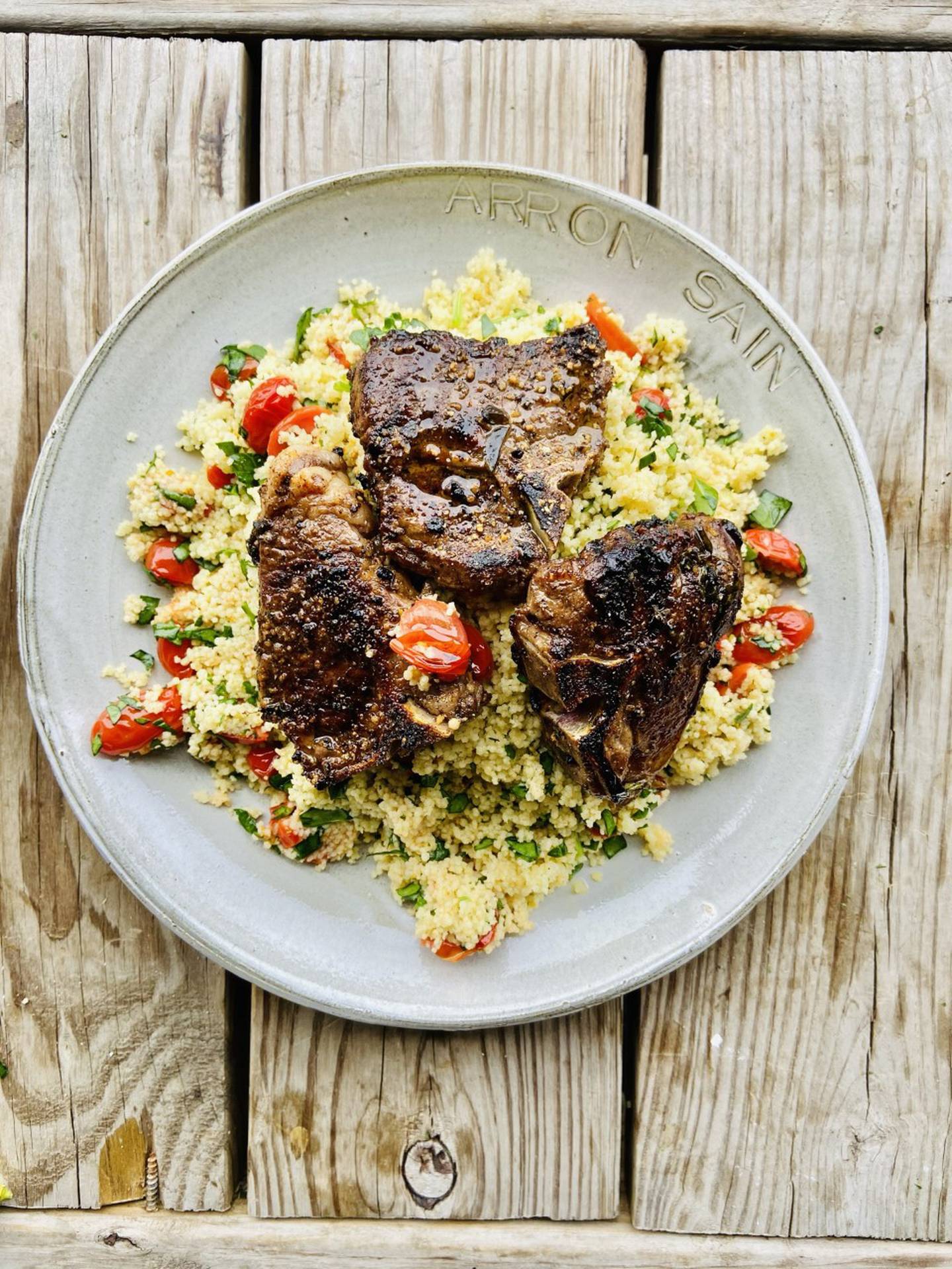 Las imágenes son chuletas de cordero chamuscadas con cuscús de tomate y espinacas creadas por Arron Sain de Plainfield, propietario de Insainly Fit Meals.