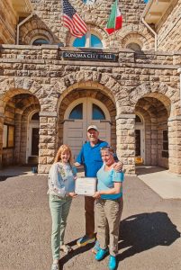 La alcaldesa Sandra Lowe entrega un certificado a Sheana Davis y Ben Sessions de The Epicurean Connection frente al Ayuntamiento el 21 de mayo de 2023.