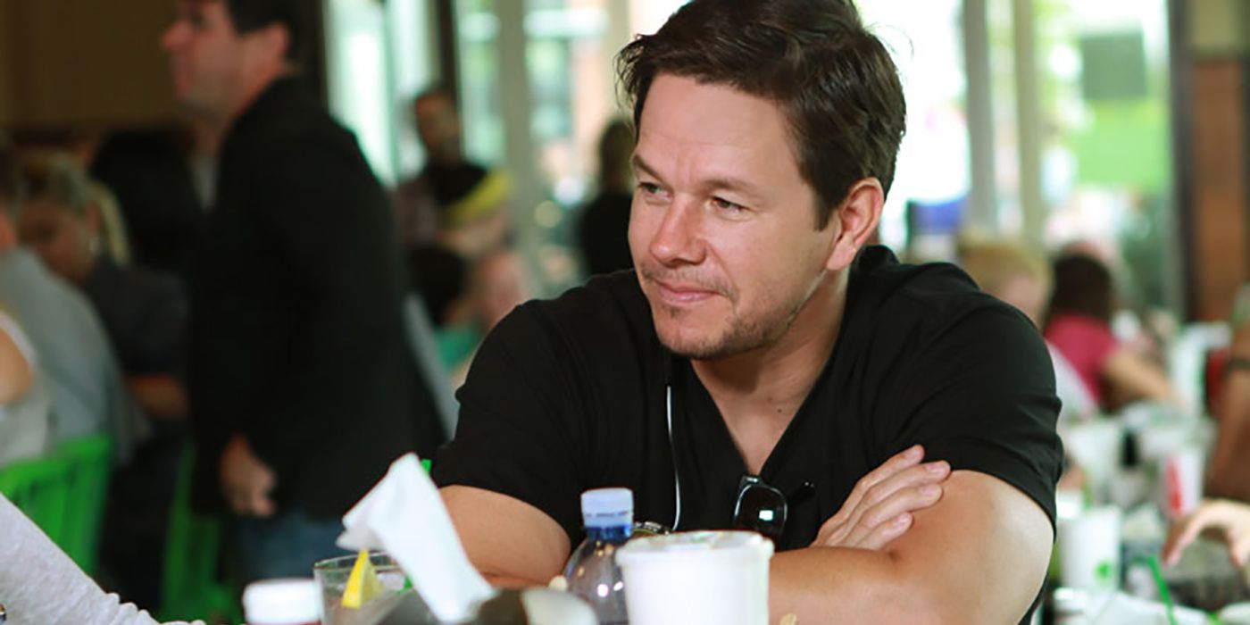 Mark Wahlberg sentado en su restaurante en una escena de Wahlburgers.