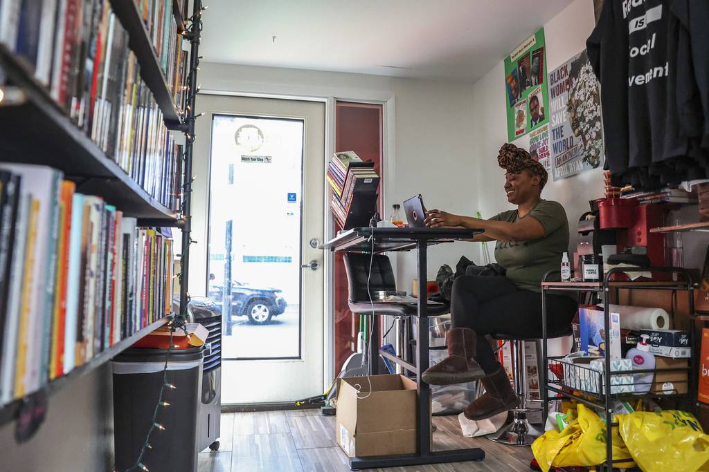 La propietaria de la tienda, Courtney Woods, trabaja dentro de Da Book Joint, una librería enfocada en autores negros el 5 de mayo de 2023, en Boxville, en el vecindario Bronzeville de Chicago. 