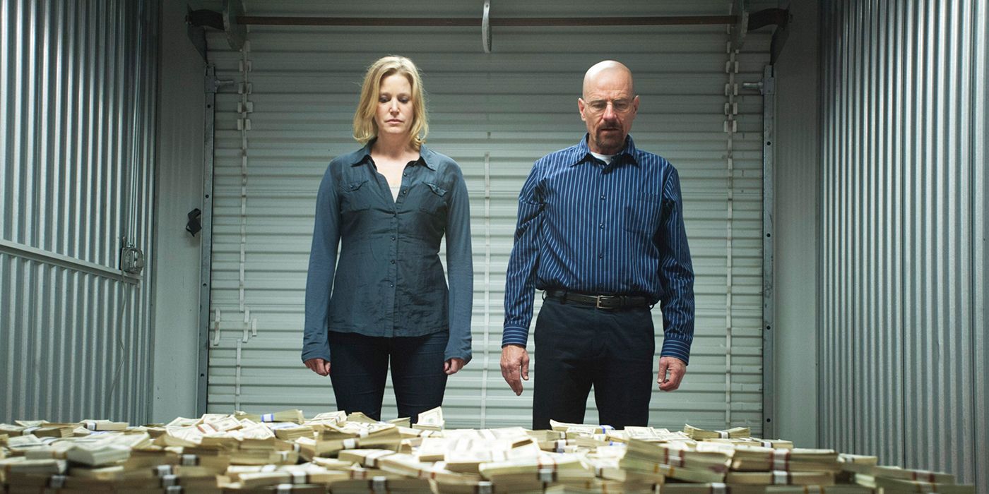 Skyler y Walter de Breaking Bad parados en una unidad de almacenamiento mirando montones de dinero.