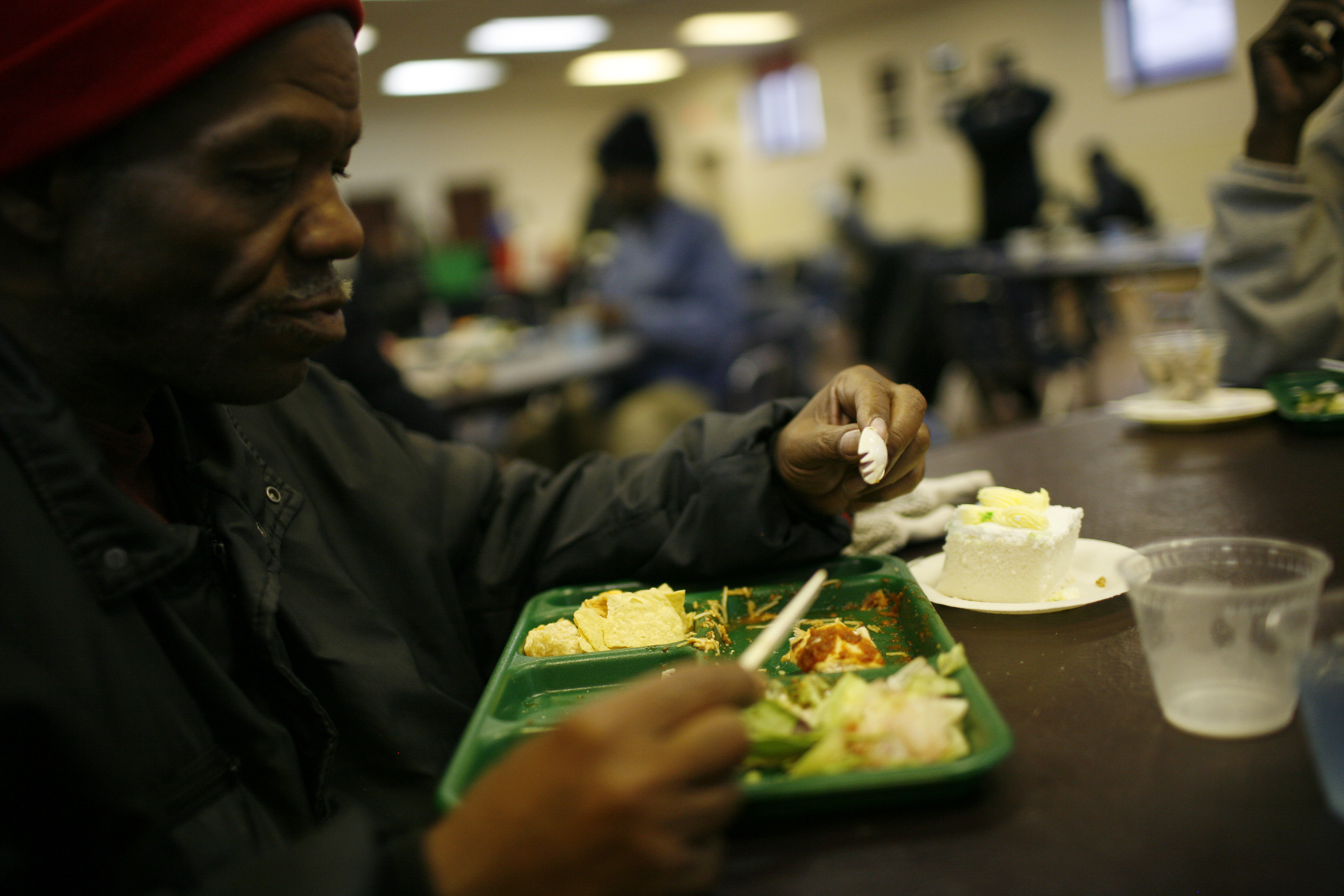 Un hombre almuerza en un comedor de beneficencia