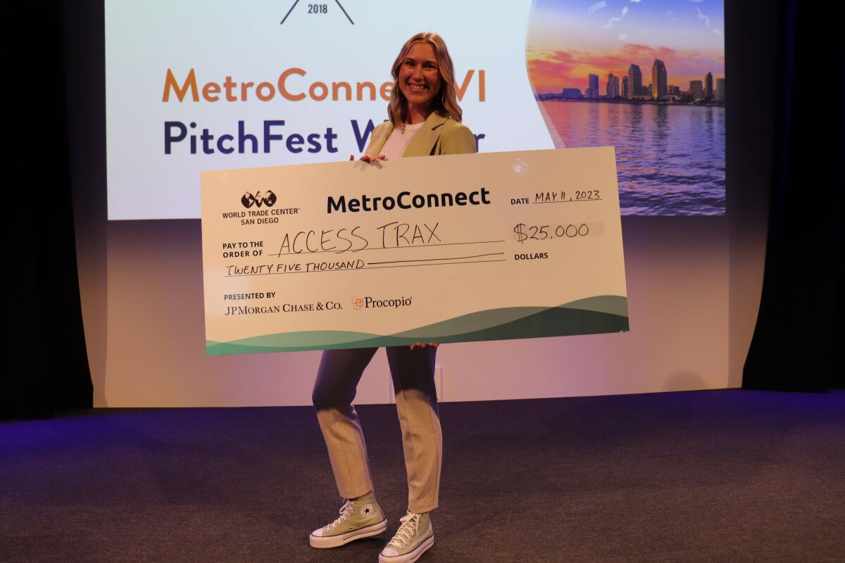 Kelly Twichel, cofundadora y directora ejecutiva de Access Trax, tiene un gran cheque de $25,000.