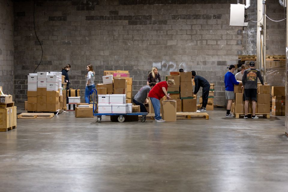 Voluntarios y miembros del International Business Club apilan paletas de libros.  Foto de David Malone. 