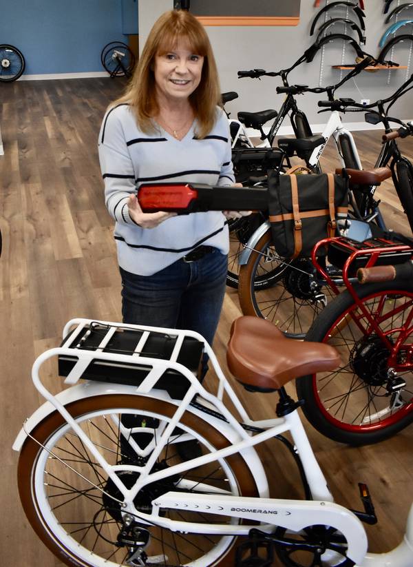 Una batería de 9 libras como la que tiene Karen Budicin en su tienda, Pedego Naperville, es todo lo que necesitas para hacer funcionar una bicicleta eléctrica, dijo.  La tienda vende una amplia gama de bicicletas eléctricas, con un costo promedio de alrededor de $3,000.