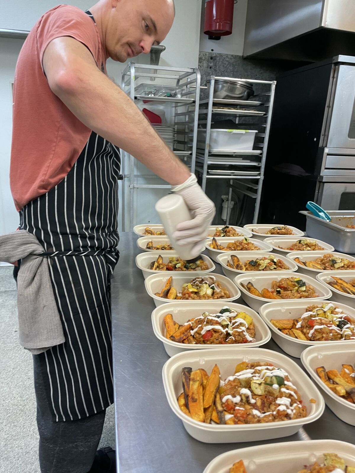 El chef y residente de La Jolla, Alec Hurley, prepara comidas para el servicio de entrega de alimentos Deeply Nourished.