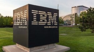 Acciones de computación cuántica: Signo de IBM con el edificio de la oficina central de Canadá en segundo plano en Markham, Ontario, Canadá.  IBM es una empresa tecnológica multinacional estadounidense.