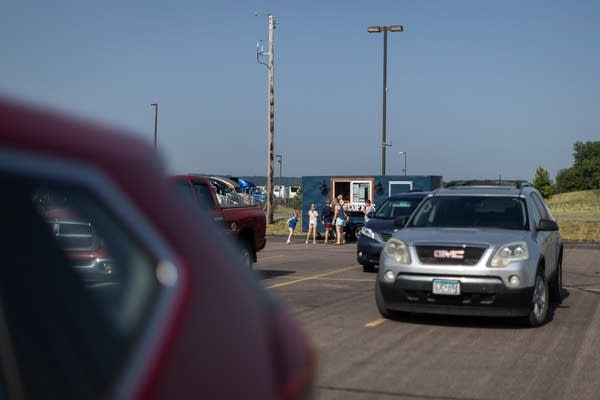 La gente pide bebidas en un estacionamiento