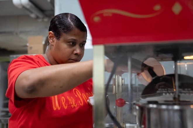 Jocelynn Porter vierte granos de palomitas de maíz en la máquina el jueves 29 de junio de 2023 en la Iglesia Metodista Unida de Broadway en Indianápolis.