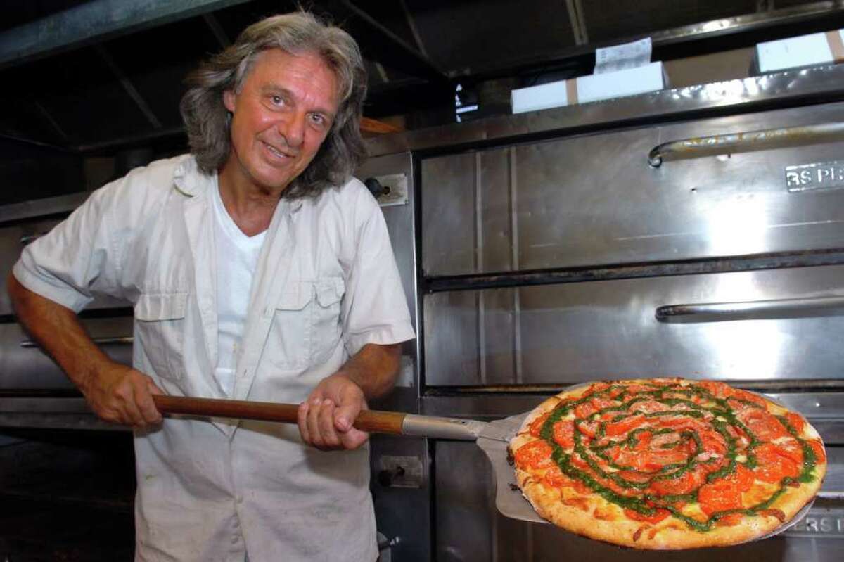 Carl Salerno sostiene una pizza de tomate pera en Salerno's Apizza, en Stratford, Connecticut, el 15 de agosto de 2011. 