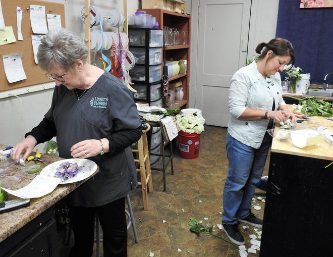 Linnet Lowe y su hija, Amanda Stickdorn, trabajan juntas en pedidos en Linnet's Flowers on the Square en Newark.  La tienda original está en Coshocton y abrió hace 27 años.