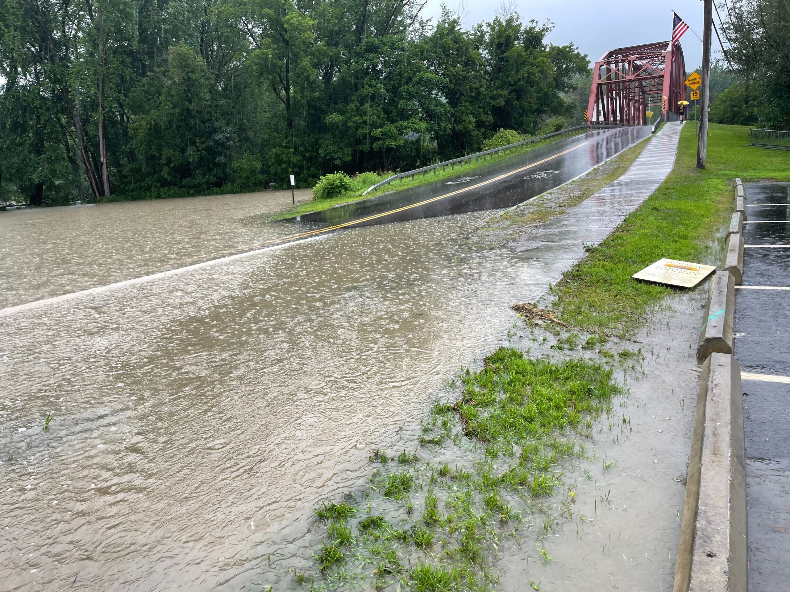 una carretera inundada con un puente al fondo.