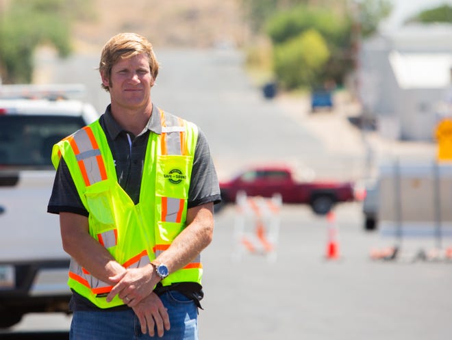 George Lane-Roberts, gerente de preconstrucción, escucha a los oradores durante una ceremonia de inauguración de un proyecto de revitalización del centro de Kingman el 10 de julio de 2023.