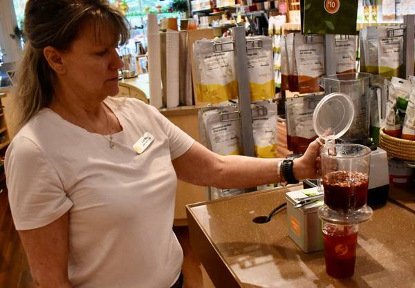 Laura Sabato, gerente de Adagio Teas en Naperville, prepara un té helado.  Son muy populares entre los clientes sin cita previa en los calurosos días de verano, dice.