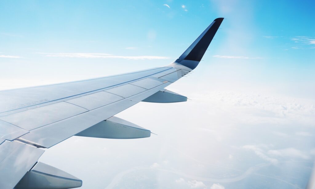 Ala de un avión volando en el cielo con nubes debajo