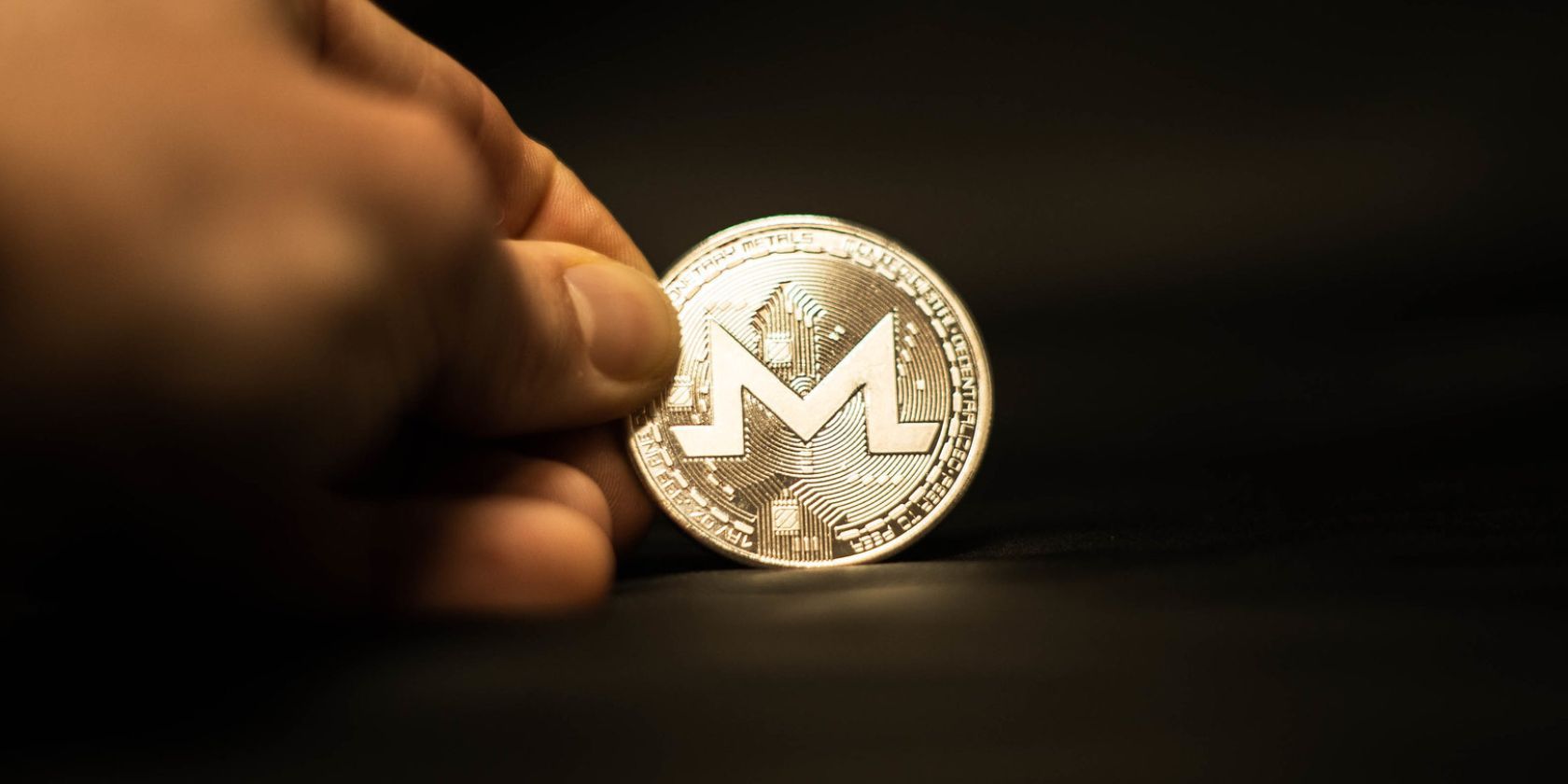 moneda monero retenida en la mano