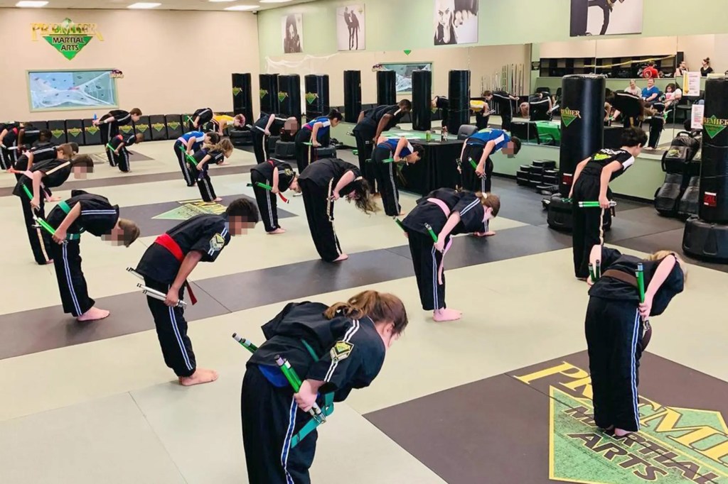 Joven estudiante de artes marciales inclinándose en clase.