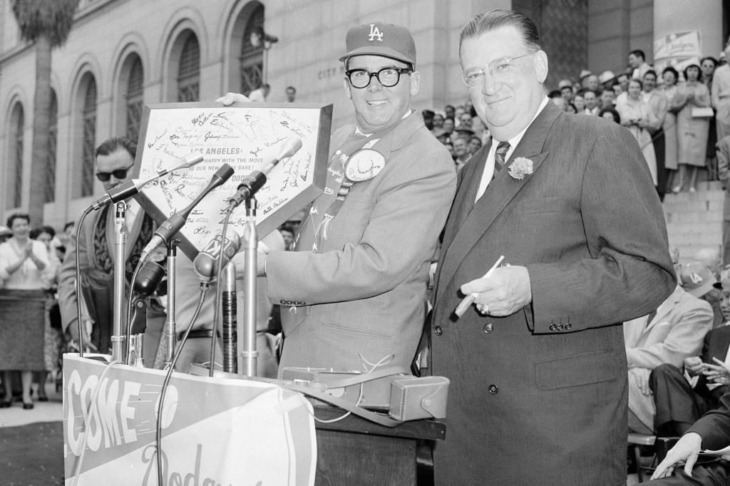 El alcalde de Los Ángeles, Norris Poulson, muestra el plato de Ebbets Field en Brooklyn, NY, presentado por el presidente de los Dodgers, Walter O'Malley, a la derecha, durante una ceremonia de bienvenida de los Dodgers en las escaleras del Ayuntamiento de Los Ángeles, California, este 18 de abril. , Foto de archivo de 1958.