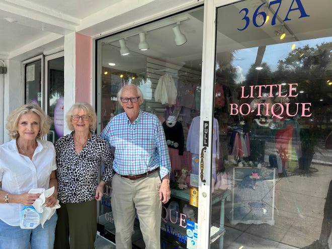 Kathy Marinacci, izquierda, y Joyce y Jim Condrack están frente a Little Bo-Tique, un negocio que los Condrack han poseído durante más de 35 años en St. Armands Circle en Sarasota el 31 de agosto de 2023. Jim Condrack, de 88 años, había pegó con cinta adhesiva las puertas y apiló bolsas de arena en el negocio, donde el agua estancada llegó a su nivel más alto que nunca.  Pero su negocio no prosperó.