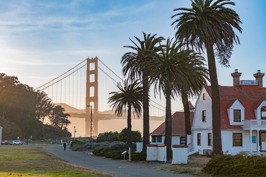 Alberga palmeras cerca del puente Golden Gate al atardecer en una cálida tarde de verano