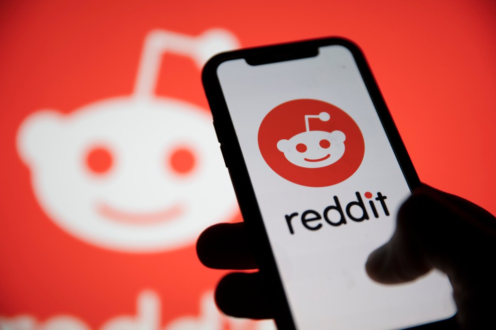 Logotipo de Reddit mostrado en un teléfono inteligente con el logotipo de Reddit de fondo