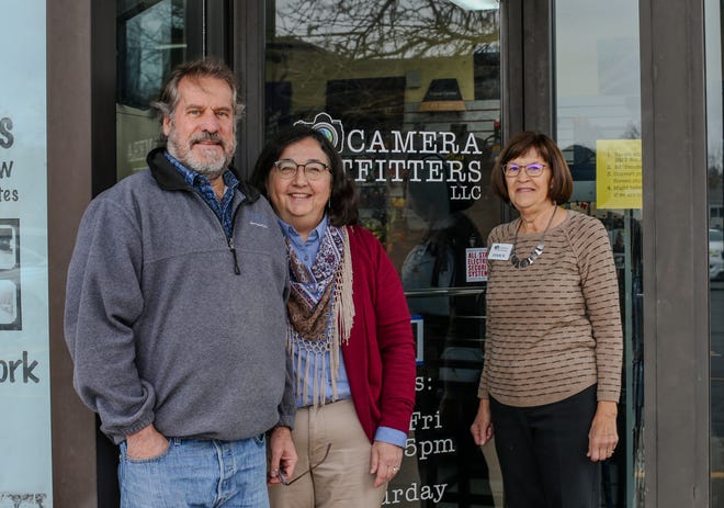 Los copropietarios Ross Aiken y Rena Aiken y la ex copropietaria Dawn Ross, posan para una fotografía fuera de la ubicación de Camera Outfitters, el viernes 17 de noviembre de 2023, en Lafayette, Indiana.