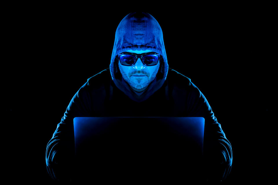 Hombre detrás de una computadora portátil, hombre hacker, computadora portátil y seguridad personal en línea