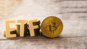 Moneda Bitcoin con texto ETF puesta en suelo de madera, Concepto de entrada al Fondo de Dinero Digital.  ETF de Bitcoin