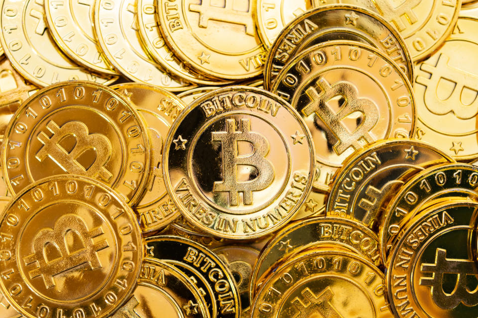 Bitcoins representados como moneda real y material.