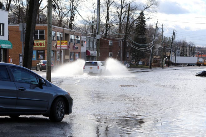 Un automovilista conduce a través de un área cerrada debido a inundaciones en la Ruta 9A en Elmsford el 10 de enero de 2024. Un tramo de negocios a lo largo de la ruta está cerrado debido a las inundaciones después de la tormenta de anoche.