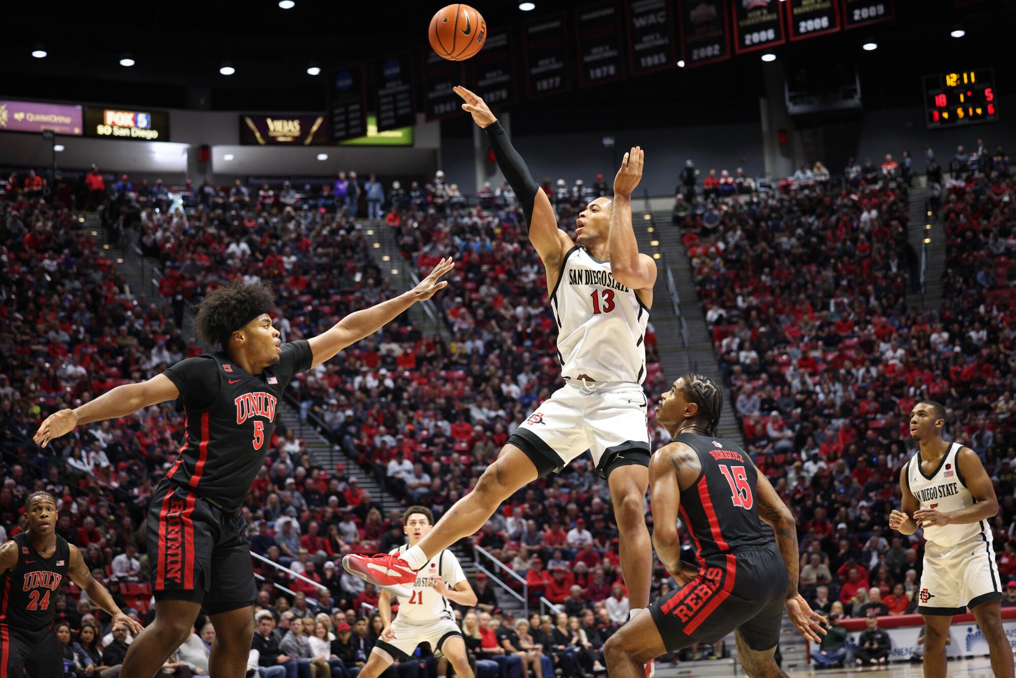 El delantero de San Diego State, Jaedon LeDee (13), se lanza a disparar contra el delantero de la UNLV, Rob Whaley Jr. (5).