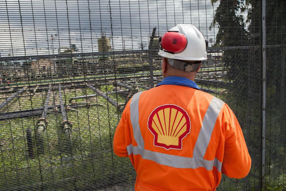 Un empleado de la estación de flujo Shell Agbada 2 observa la estación desde detrás de una puerta en Port Harcourt el 30 de septiembre de 2015. Nigeria es el mayor productor de África y representa aproximadamente dos millones de barriles de crudo al día.  Shell ha culpado a los repetidos robos de petróleo y al sabotaje de oleoductos clave como la principal causa de los derrames y la contaminación en la región productora de petróleo.  AFP PHOTO / FLORIAN PLAUCHEUR (El crédito de la foto debe decir FLORIAN PLAUCHEUR/AFP vía Getty Images)